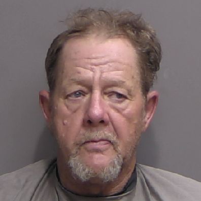 A middle aged man with short, light brown hair and a trimmed goatee, wearing a gray shirt, facing forward against a plain background